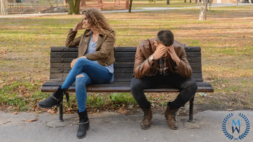 couple upset sitting on park bench