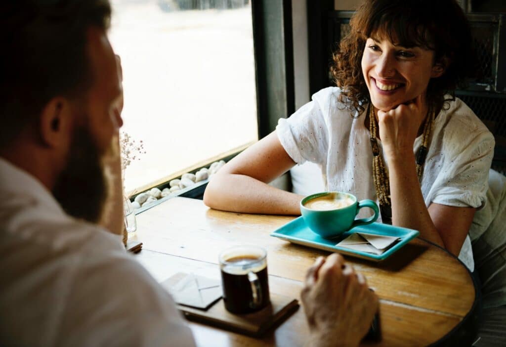woman happily speaking to man at a table