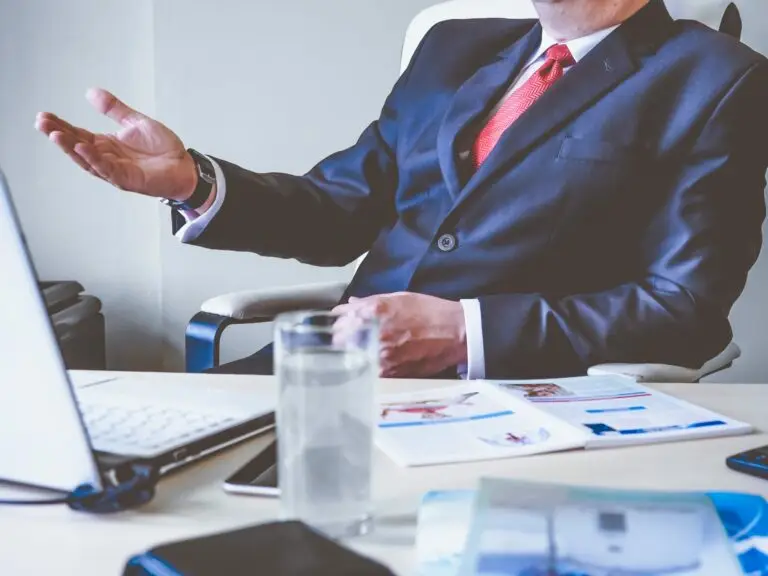 executive sitting at desk making hand gesture