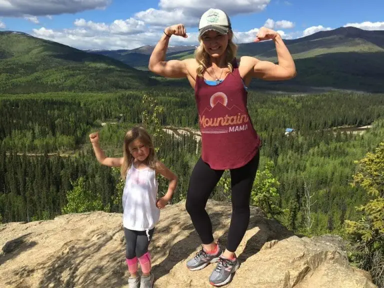 woman and child flexing muscles in the mountains