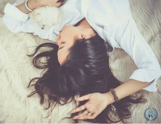 woman laying on furry blanket with puppy