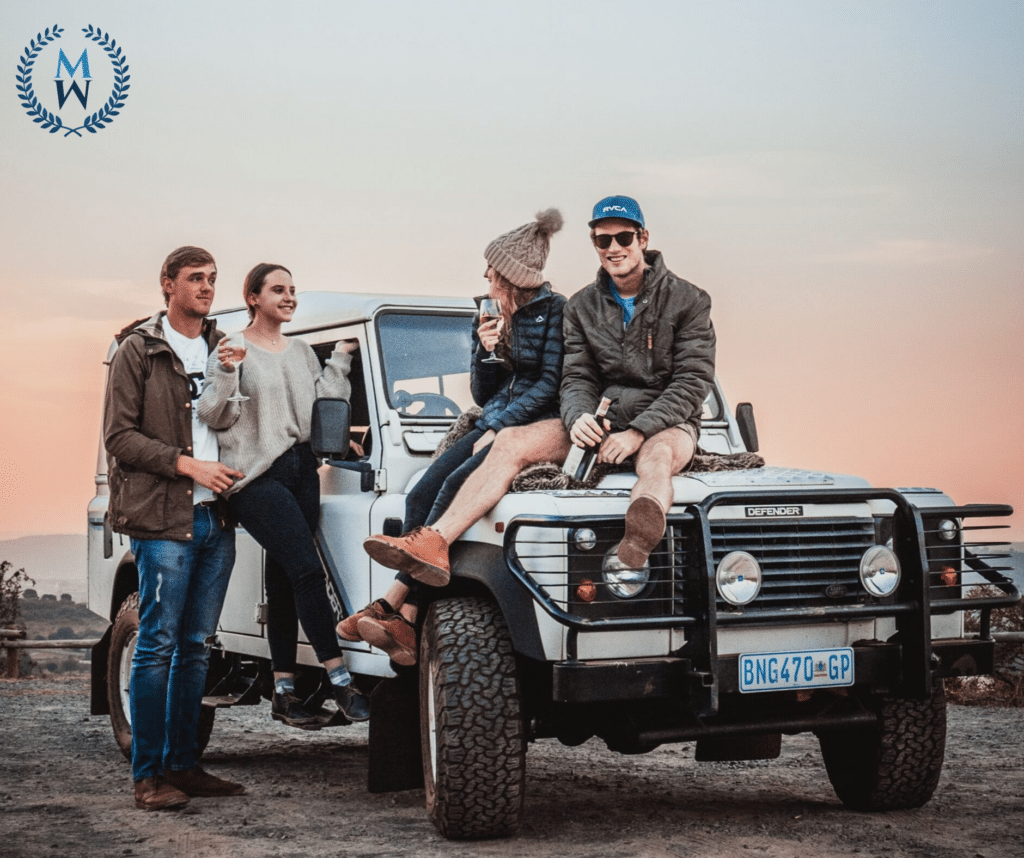 group of friends sitting on a jeep