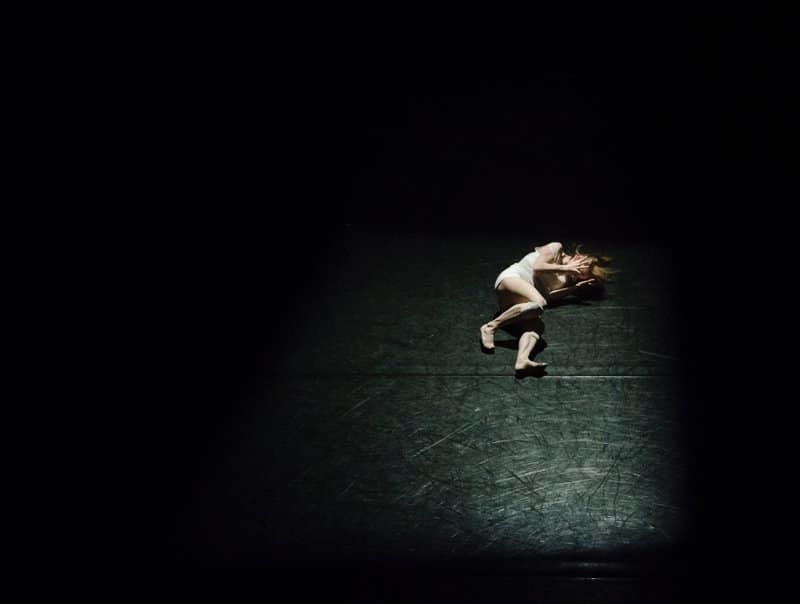 woman laying on floor in dark