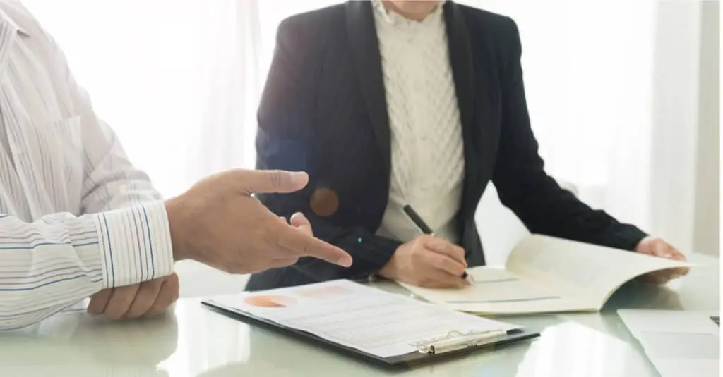 woman in meeting writing down info