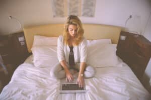 woman in bed doing online counseling