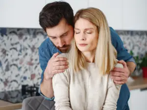 A man and woman in a stilted, uncomfortable embrace, indicating that one or both individuals may be people with narcissism.