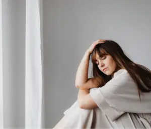 A woman trying to comfort herself while thinking about the grief stage of accepting death