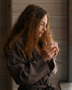 Woman experiencing the apathy paradox with a cup of tea by a window