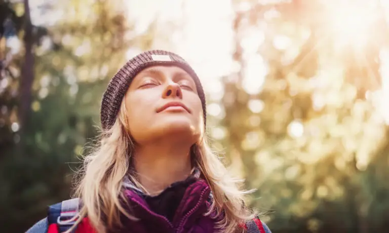 woman hiking outside taking a deep breath
