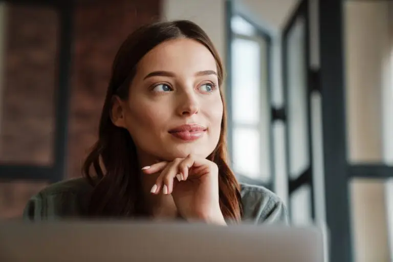 A young brunette woman looking off to the side, happy to know more about the different types of OCD so she can get the help she needs.