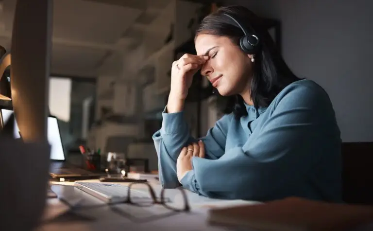 A young brunette woman overcome by stress from a toxic work environment.