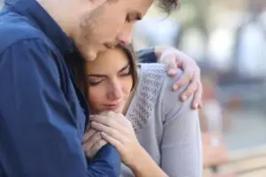 A couple in an embrace supporting each other while healing from trauma together.