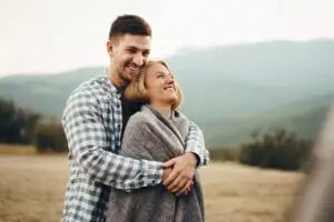 A young couple embracing while outdoors.