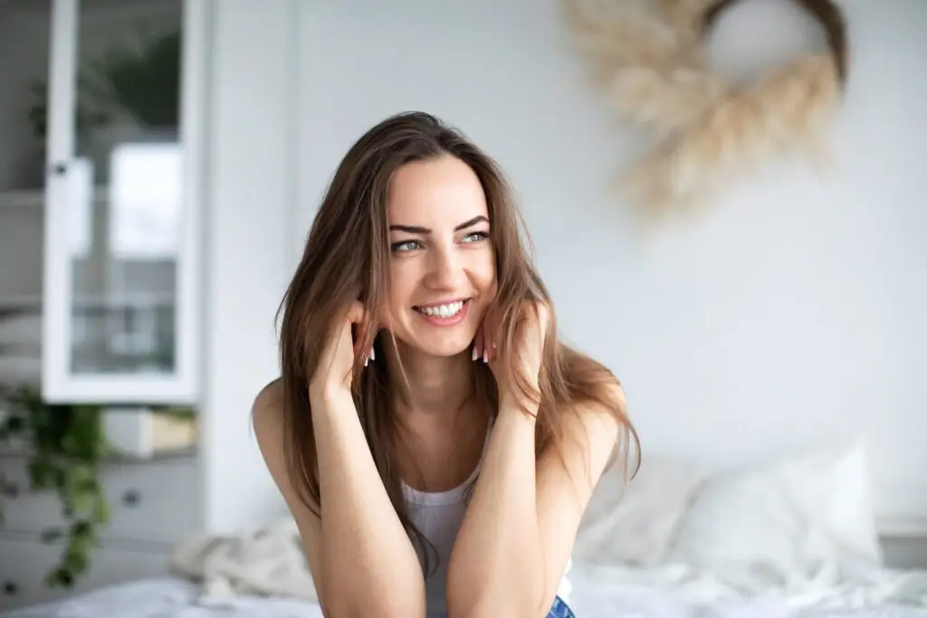 What to do when you're feeling unappreciated a woman smiling, feeling comfortable because she set boundaries with those around her.