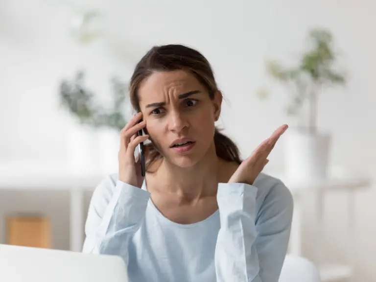 A woman arguing on the phone, trying to stop feeling irritable