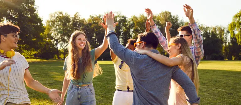 Introvert vs Extrovert: How to embrace your authentic self Group of happy cheerful young friends meeting in park and having fun all together