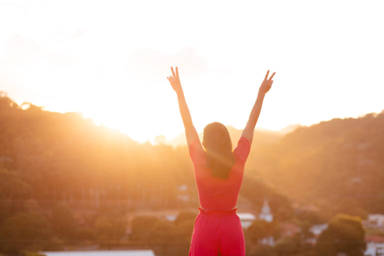 What is ADHD Paralysis? Discover 10 Ways to Rebound A photo of a woman raising her arms signifying that she found the answer to “What is ADHD paralysis?”.