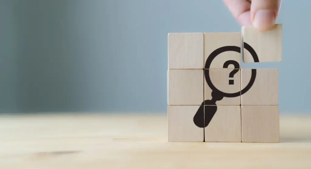 What is ADHD Paralysis? Discover 10 Ways to Rebound A block puzzle featuring a magnifying glass graphic, as a visual representation of our attempt to examine the causes of ADHD paralysis.