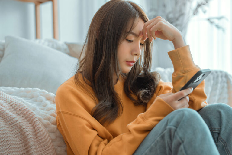 ADHD Object Permanence: What it Really Means and 7 Essential Tips on Managing It Working memory struggles can lead to not remembering to text back. This girl is looking at her phone with a neutral expression.