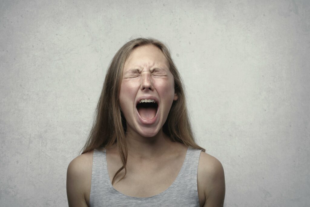 A distressed woman mid-emotional outburst, illustrating the crash out meaning as a sudden, intense release of built-up emotions.