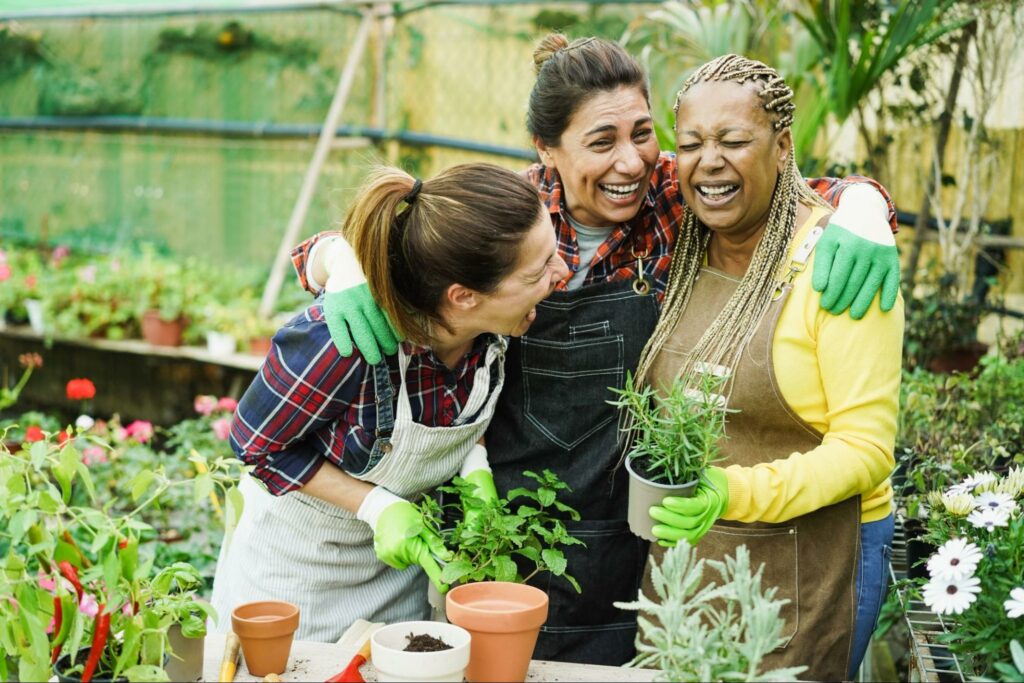 Three women enjoying a greenhouse as they successfully move in generativity instead of stagnation