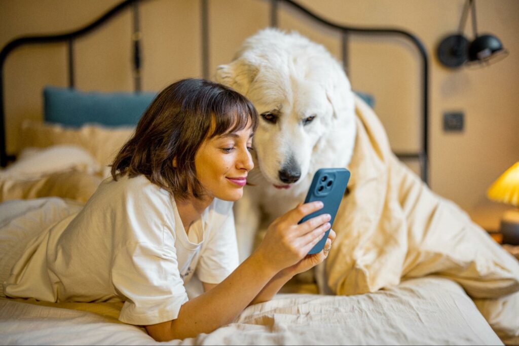 Young woman and her Grand Pyrenees scrolling through social media together.