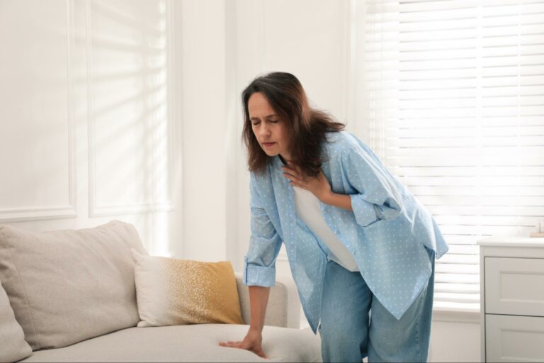 Makin Wellness Articles A woman in distress, desperately wondering how to tell if shortness of breath is from anxiety.