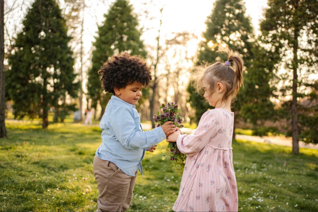 Children exploring cultural identity as they enjoy flowers during golden hour.