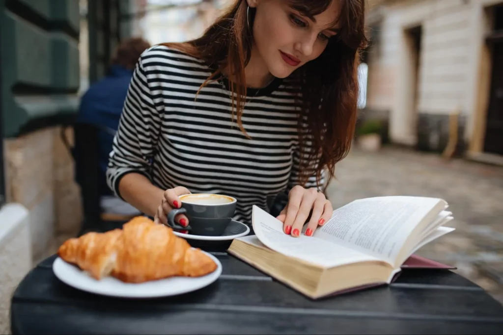 After identifying a lack of self esteem in her life, a young woman is free to enjoy the person that she wants to be more fully, while reading a book at a cafe.