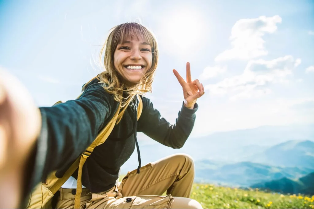 A woman out for a hike, enjoying a beautiful day as a way to boost her mood.