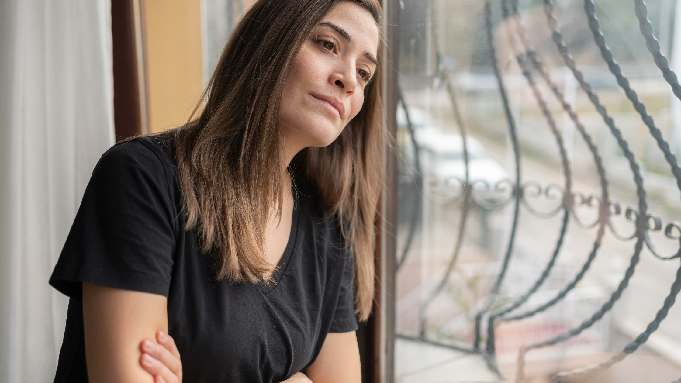 Grief Support: How Can Counseling Help You Cope With Loss? A person looking out the window quietly and reflecting while coping with grief