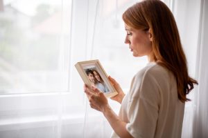 A person reflecting on the loss of a loved one while seeking grief support