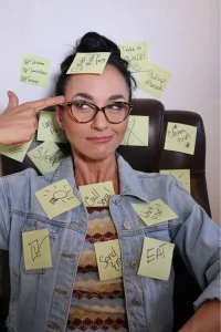A young woman covered in sticky notes, representing different ADHD symptoms in women.