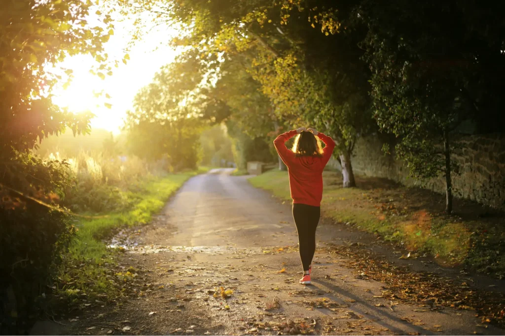 A young woman with ADHD on a run, feeling hopeful about managing ADHD signs in women through online therapy and self-compassion.