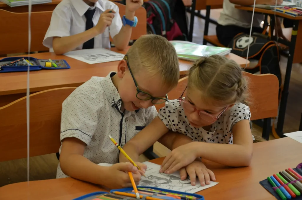 A young boy and girl at school who may have ADHD, though the girl may not be diagnosed because signs of ADHD in females are more easily missed than those in boys.