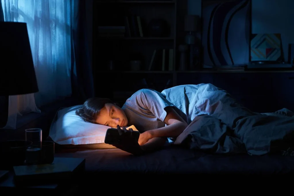 A teenage girl stimming on her phone staying up late at night.