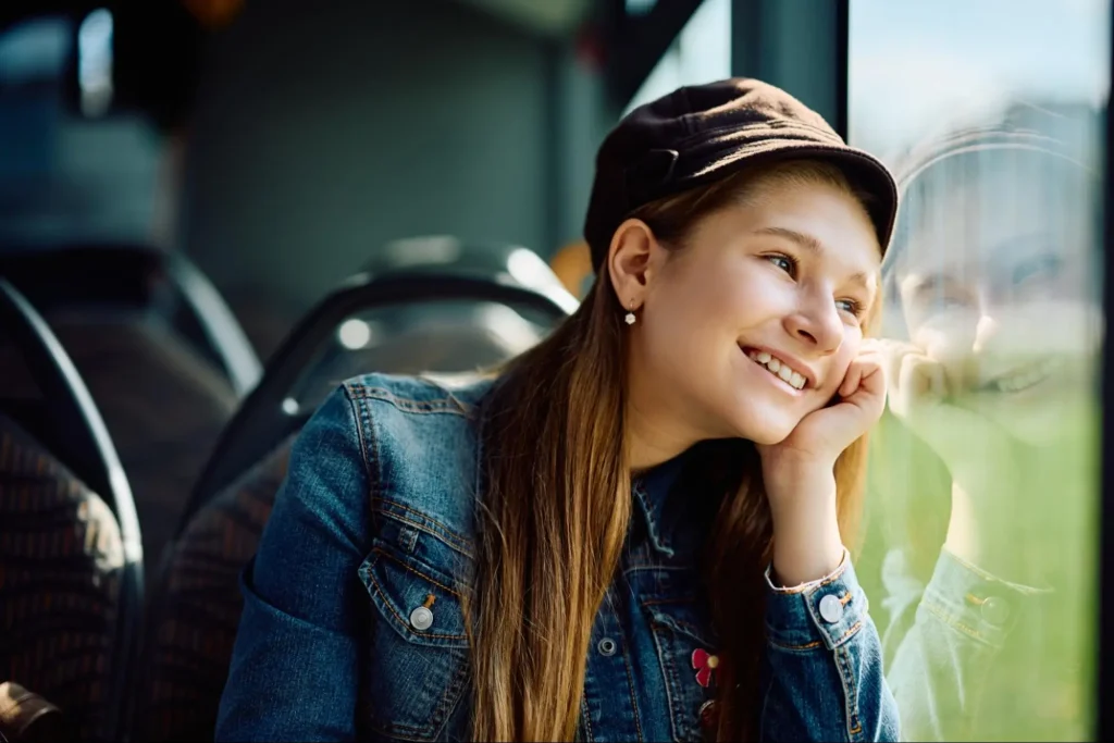 A girl looking out the window daydreaming shows one symptom of ADHD in girls.