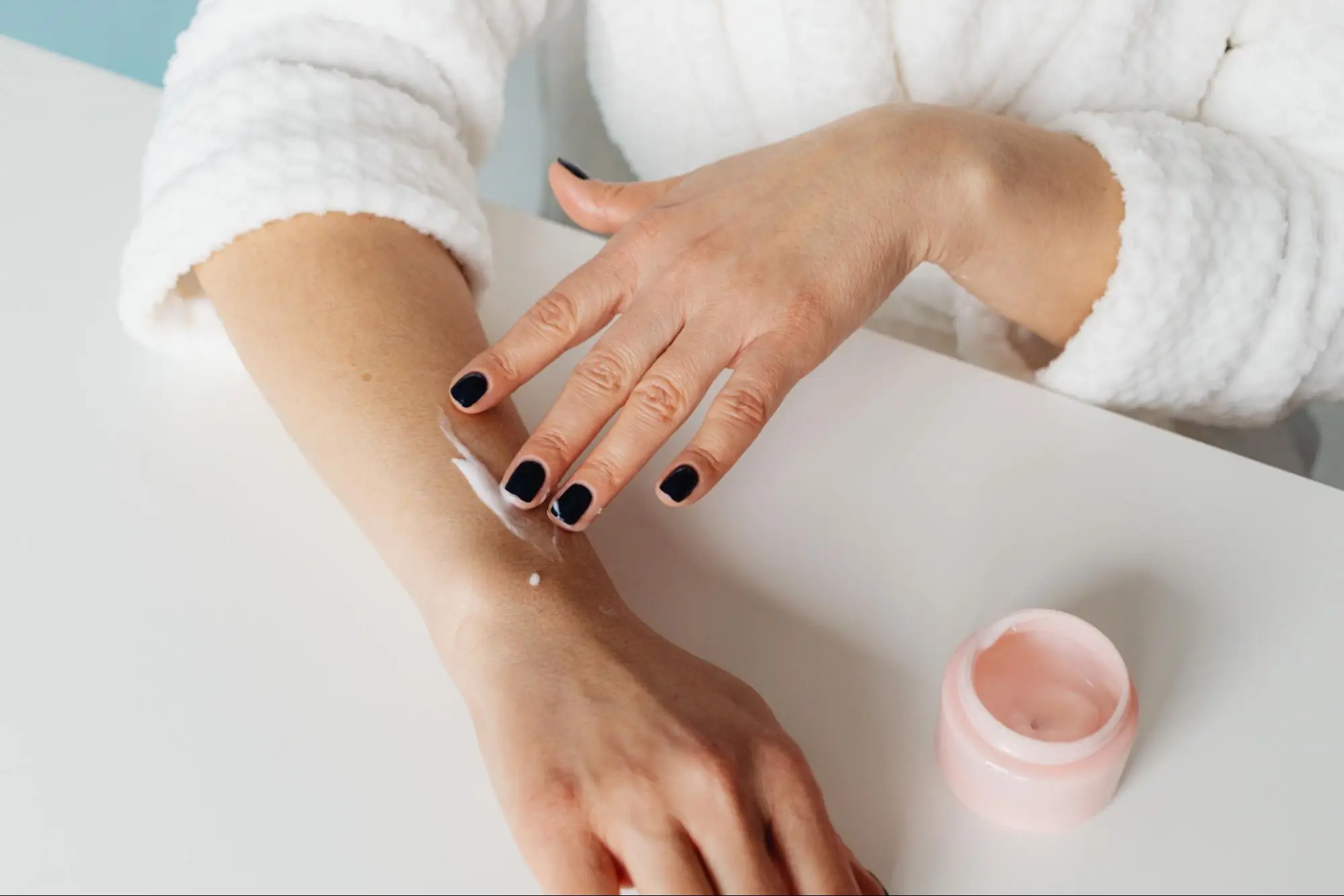 A woman is applying lotion to ease her somatic OCD symptom of itching.