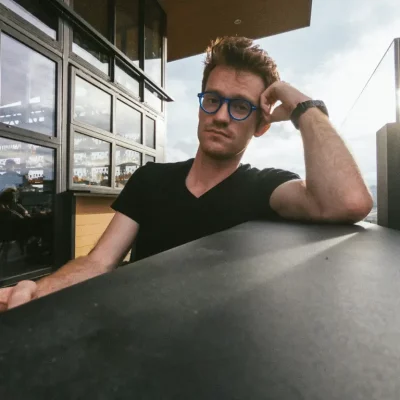 man looking into camera at outdoor rooftop bar