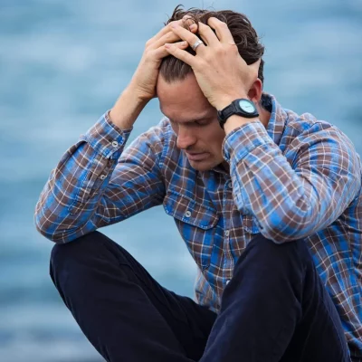 sad man running hand through hair