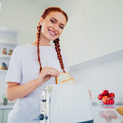 Photo of pretty cute girl cooking delicious breakfast toast white light interior kitchen room daylight indoors.