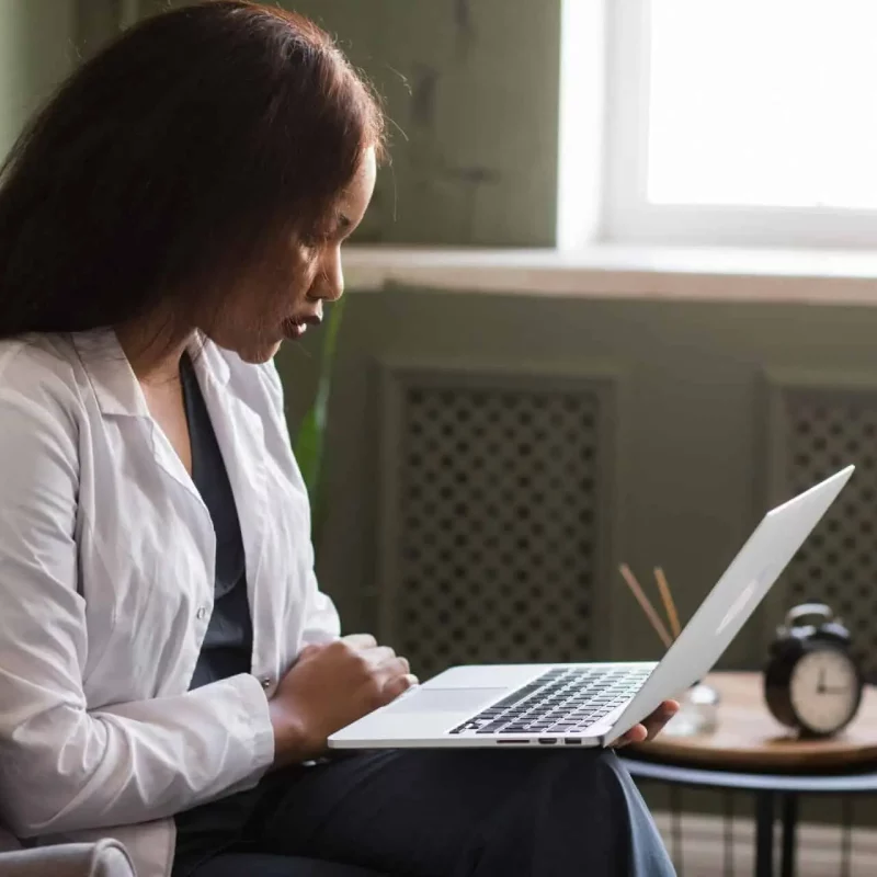 Female african doctor talking on conference video call. Virtual therapist consulting during online appointment on laptop at home. Telemedicine chat, telehealth meeting.