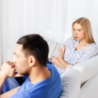A couple on the couch not speaking, resulting in conflict avoidance