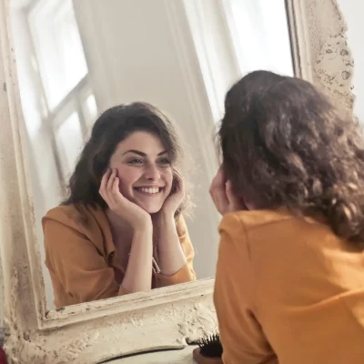 happy woman looking in the mirror