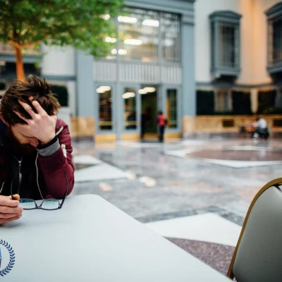 upset man sitting at outdoor plaza table