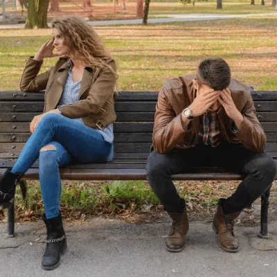 couple upset sitting on park bench