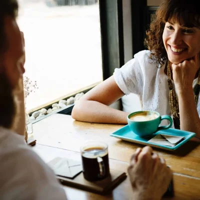 woman happily speaking to man at a table