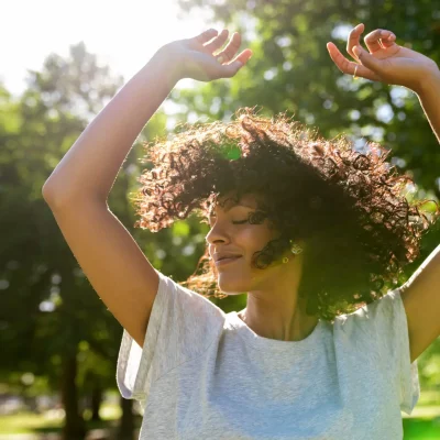 Carefree woman dancing in a park on a sunny afternoon