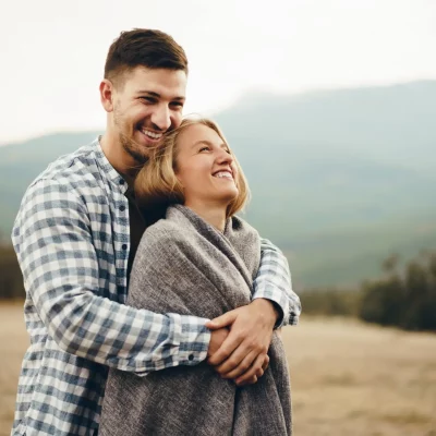A young couple embracing while outdoors.