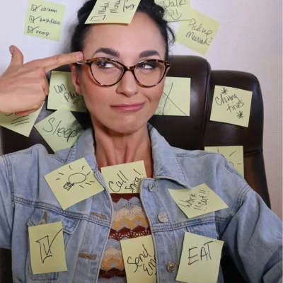 A young woman covered in sticky notes, representing different ADHD symptoms in women.